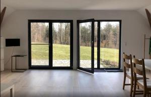 une chambre avec trois portes offrant une vue sur un champ dans l'établissement Bauernhaus Pledlberg, à Winzer
