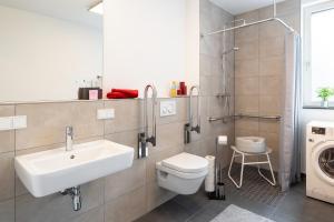 a bathroom with a sink toilet and a washing machine at Ferienhaus Altstadtblick Bad Wildungen in Bad Wildungen +20 photos