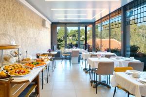 a restaurant with white tables and chairs and windows at Sintra Bliss Hotel in Sintra