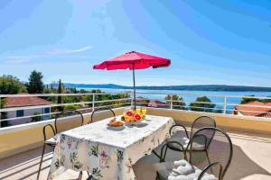 a table with a red umbrella on a balcony at Apartment in Crikvenica 14104 in Sopaljska