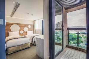 um quarto de hotel com duas camas e uma grande janela em Green World SongShan em Taipei