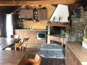 a kitchen with a stone fireplace and wooden cabinets at Къща за гости Виевци in Vievo