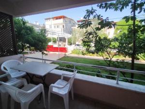 einen Balkon mit einem Tisch und Stühlen sowie einem Fenster in der Unterkunft Berk Apart Hotel in Küçükkuyu