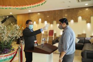 Ein Mann und eine Frau tragen Masken in einer Lobby. in der Unterkunft Hotel Alleviate in Agra