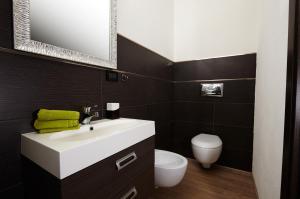 ein Badezimmer mit einem weißen Waschbecken und einem WC in der Unterkunft B&B La Bouganville in Alghero