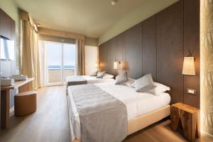 a hotel room with two beds and a large window at Hotel Life in Rimini