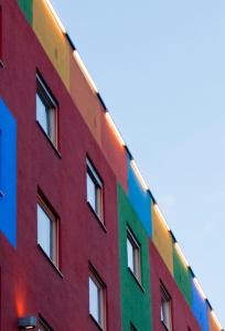 ein hohes Gebäude mit einer Regenbogen-Fassade in der Unterkunft 1st Creatif Hotel Elephant in München