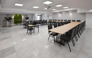 une salle de conférence avec des tables et des chaises en bois dans l'établissement Fotex, à Ząbki