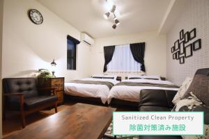 a bedroom with two beds and a chair at Origami Residential Suite - Tokyo Asakusa Skytree in Tokyo +62 photos