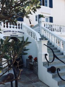 eine Treppe, die zu einem Gebäude mit einem Schild führt in der Unterkunft Grand Hôtel de la Poste in Saint-Jean-de-Luz