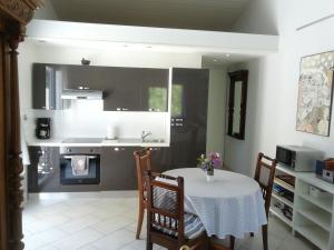 eine Küche mit einem Tisch und einem weißen Tischtuch in der Unterkunft Le Quatorze in Laroque-des-Albères