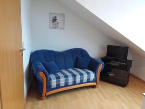 リンダウにあるFerienwohnung Nicole Bufflerのリビングルーム(青いソファ、テレビ付)