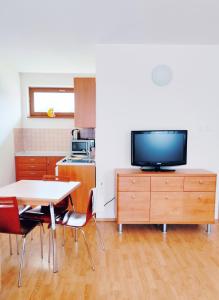 een keuken met een tafel en een tv op een kast bij Apartmán 302 Oščadnica in Oščadnica