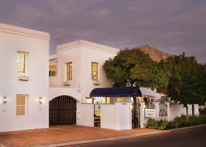 una casa blanca con una puerta y un árbol en Batavia Boutique Hotel, en Stellenbosch