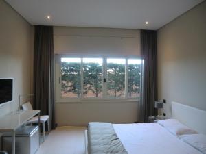 1 dormitorio con cama y ventana grande en B&Beach Cagliari guest house, en Cagliari