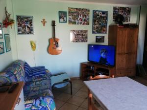 een woonkamer met een bank en een tv bij Trilocale con box cantina a Robilante in Robilante