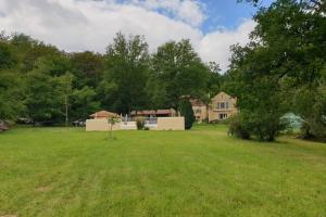 a large yard with a house in the background at Domaine du Bois Noir in Milhac