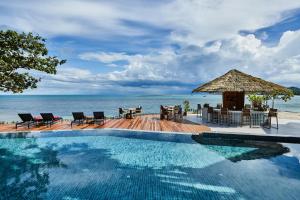 a swimming pool with a table and chairs and the ocean at Rocky's Boutique Resort - Veranda Collection Samui - SHA Extra Plus in Lamai
