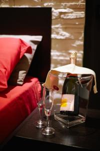 eine Flasche Wein und zwei Gläser auf dem Tisch in der Unterkunft B&B La Bouganville in Alghero