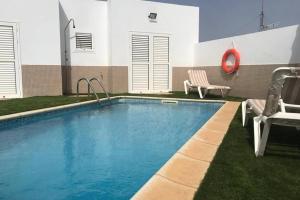 a swimming pool with a slide in front of a building at VV VALDECONCHA, piscina climatizada con SPA privado y vistas al mar in Caleta De Fuste