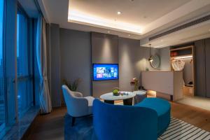 sala de estar con sillas azules y mesa en SSAW Boutique Hotel Wenzhou Dexin en Wenzhou