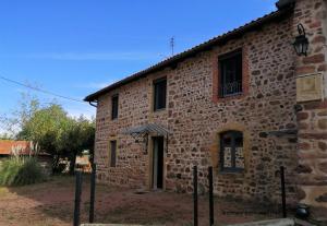 an old stone building with a gate in front of it at Les demeures champêtres in Jarnosse