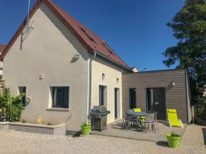 a white house with a patio and a grill at Le jardin des Arums in Givry
