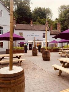 a group of picnic tables and umbrellas in front of a building at The Malthouse in Ironbridge