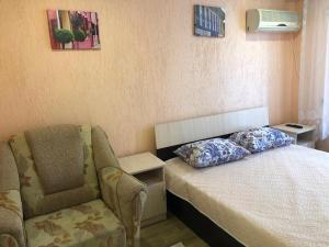 エイスクにあるГостевой дом «Солнечный берег»のベッドルーム1室(椅子、ベッド1台、枕付)