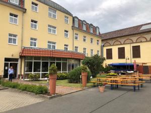 a group of tables and benches in front of a building at Brandiser Parkhotel in Brandis