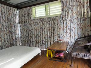 羅東鎮的住宿－蘭卡威羅東庭園民宿，一间卧室配有一张床、一张桌子和一个窗户。