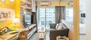 a living room with a couch and a table with a desk at Lumpini Parkbeach Pattaya Pool View in Jomtien Beach