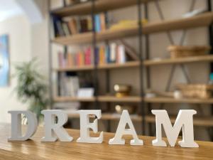 a wooden table with the word relax written in front of a book shelf at Sunshine Residence in Stara Baška