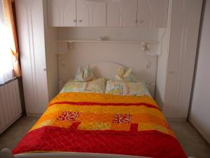 ザラカロシュにあるApartments in Zalakaros/Thermalbad 20667のカラフルなキルトのベッドが備わる客室です。