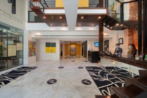 The Picasso Boutique Serviced Residences Managed by HII في مانيلا: لوبي مبنى فيه ناس