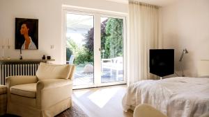 um quarto com uma cama e uma cadeira e uma porta de vidro deslizante em Ferienwohnung Jung&Lind em Bretten