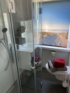 a bathroom with a shower with a view of the beach at Ferienhaus Scandia am See in Warnitz