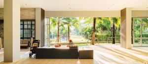 a living room with a view of palm trees at Lumpini Parkbeach Pattaya Pool View in Jomtien Beach