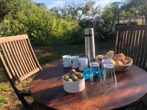 a wooden table with a basket of fruit and jars on it at Le bleu Levant in Vaux-devant-Damloup