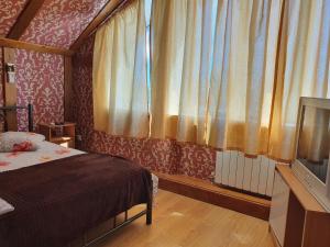 a bedroom with a bed and a window with curtains at Hotel Economy Classa Edelweiss in Nevinnomyssk