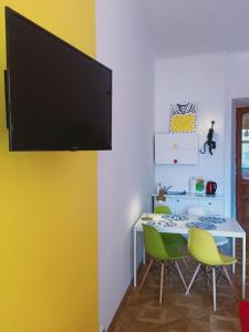 een eetkamer met een tafel en een flatscreen-tv aan de muur bij Main Square - Pollack's House in Krakau