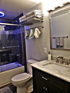 a bathroom with a sink and a toilet and a tub at Ali'i Banyan Breeze in Kailua-Kona