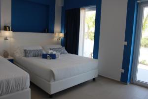 a bedroom with a large white bed with blue walls at Terrazze Naos in San Leone