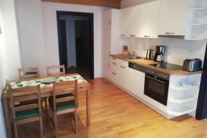 a kitchen with a wooden table and a dining room at Klein und Fein in Spital am Pyhrn