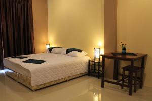 a bedroom with a bed and a table with a table at Avalon Residence in Savannakhet