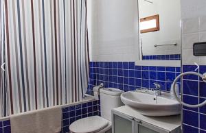 a blue and white bathroom with a toilet and a sink at La Casa del Balcón in Caravaca de la Cruz