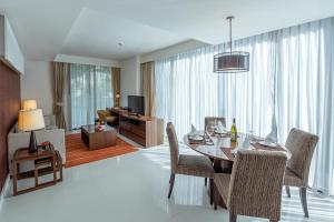バンコクにあるOakwood Residence Sukhumvit 24 Bangkokのリビングルーム(テーブル、椅子付)、