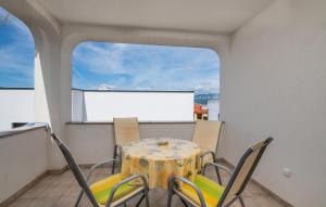einen Tisch und Stühle auf einem Balkon mit einem Bildschirm in der Unterkunft Apartment Rudika in Klimno