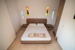 a bedroom with two beds and two windows at Kassianis House Mytikas in Kalamitsi