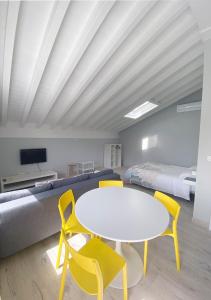 Habitación con mesa blanca, sillas y cama en La Fragua, en Santillana del Mar